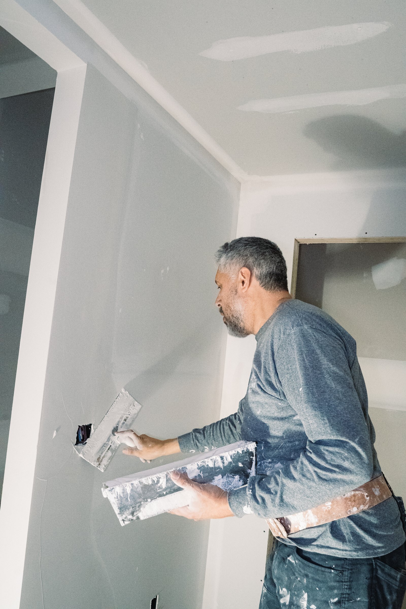 Man applying joint compound to drywall